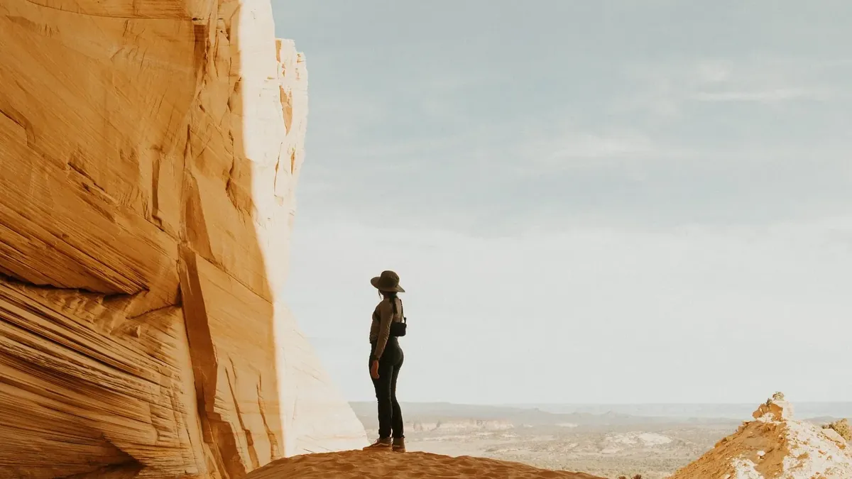 A guest standing on the sand dune inside the Great Chamber, looking out over the desert